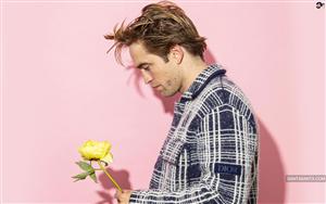 Handsome Robert Pattinson in blue & white check-shirt holding a yellow flower